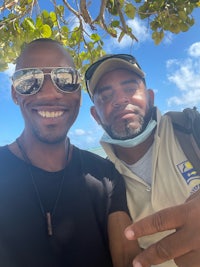 two men posing for a selfie on the beach